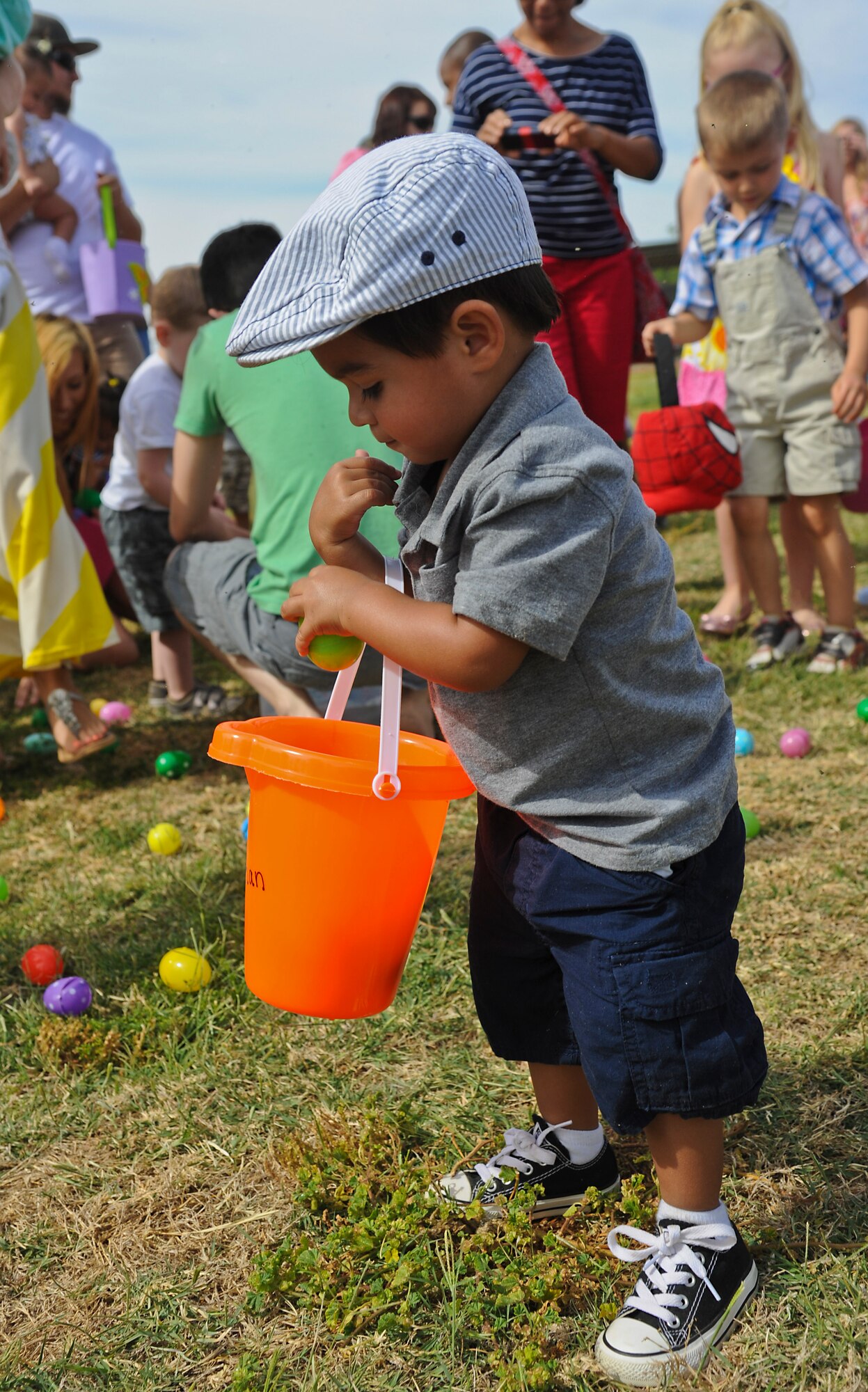 Ethan Mercado, 2, son of Master Sgt. Victor Mercado, 56th Equipment Maintenance Squadron production superintendent, gathers eggs during the egg hunt. An estimated 8,000 plastic eggs were used during this year’s event. (U.S. Air Force photo/Staff Sgt. Darlene Seltmann)