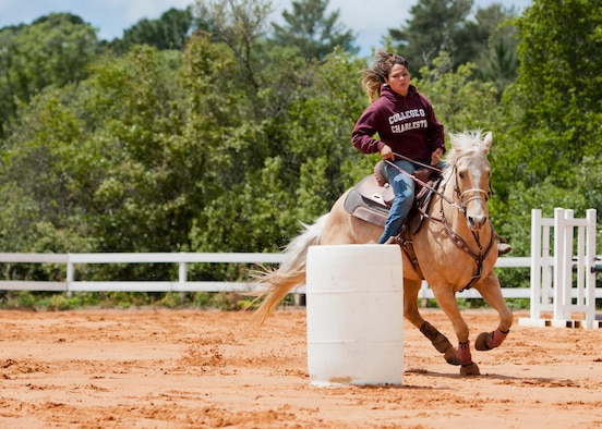 A rider and her horse perform a barrel run demonstration at the Sand and Spur Riding Club open house event April 19 at Eglin Air Force Base, Fla. The club provided pony rides for kids and riding and training demonstrations. Those who attended got an up close and hands-on experience with many of the different breeds of horses housed at the stables on base. (U.S. Air Force photo/Samuel King Jr.)