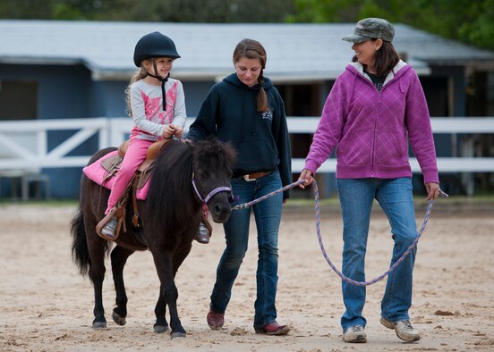 A new rider takes a trip around the ring on a small horse during the Sand and Spur Riding Club open house event April 19 at Eglin Air Force Base, Fla.  The club provided pony rides for kids and riding and training demonstrations. Those who attended got an up close and hands-on experience with many of the different breeds of horses housed at the stables on base. (U.S. Air Force photo/Samuel King Jr.)