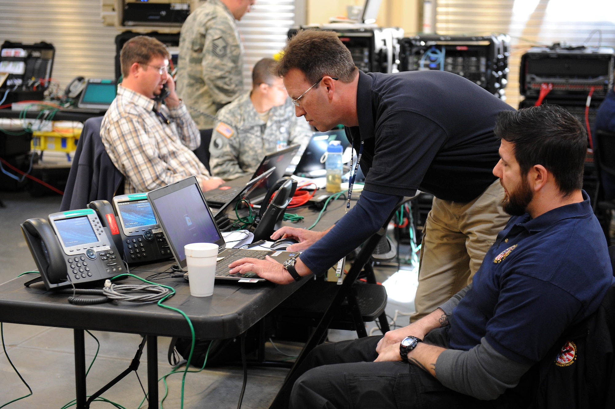 Rick George, Joint Task Force Civil Support communications control center chief, and Karl Ludwig, JTF-CS deployed communications technician, check the connection of their deployed communications gear during an internal communication exercise at Fort Eustis, Va., April 16, 2014. Members of the communications directorate conducted an internal exercise to validate their communications equipment in preparation for the upcoming Sudden Response command post exercise in May and to train new personnel. JTF-CS anticipates, plans and prepares for chemical, biological, radiological and nuclear defense support to civil authorities. (Department of Defense photo by U.S. Navy Petty Officer 1st Class Brian Dietrick/Released)