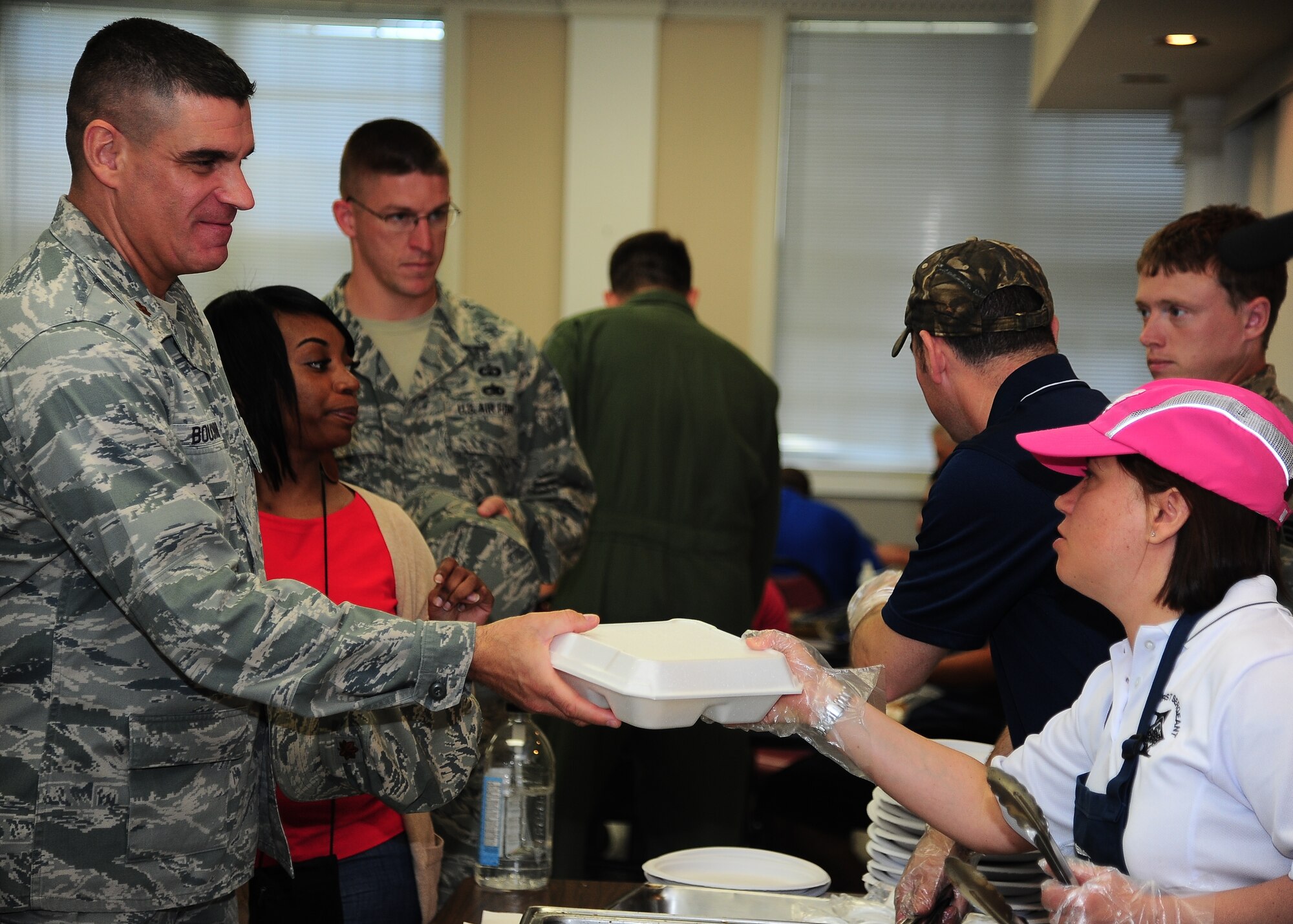 Master Sgt. Maria Rodriguez, 14th Civil Engineer Squadron First Sergeant, right, hands over a steak lunch to-go at the First Sergeant’s Steak Burn held April 11 at the Chapel Annex. Steak Burns are held on a quarterly basis as a means to fund Operation Warm Heart, a charity that gives back to the Airmen on base. (U.S. Air Force photo by Airman 1st Class Stephanie Englar)