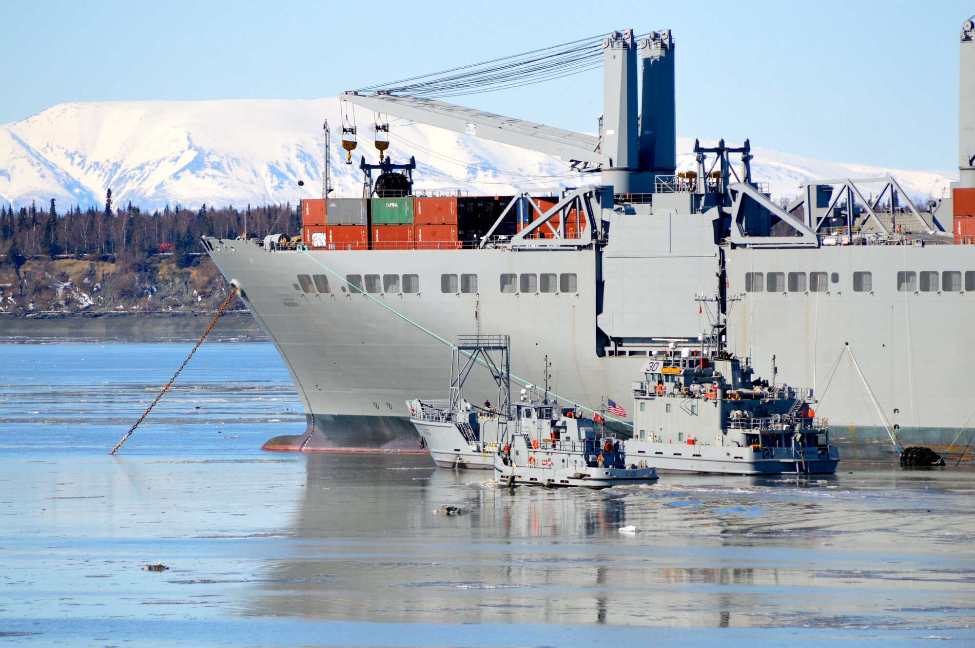 A U.S. Army landing craft utility pulls alongside the U.S. Navy’s USNS Mendonca to receive cargo during Joint Logistics Over-the-Shore operations as part of Alaska Shield 14 in Anchorage, Alaska, April 3, 2014. The small tug alongside the LVU prevented drastic movement due to strong currents in the port, allowing the Service members to safely and successfully execute the cargo transfer. (U.S. Army photo by Sgt. Stefanie D. Warner/Released)