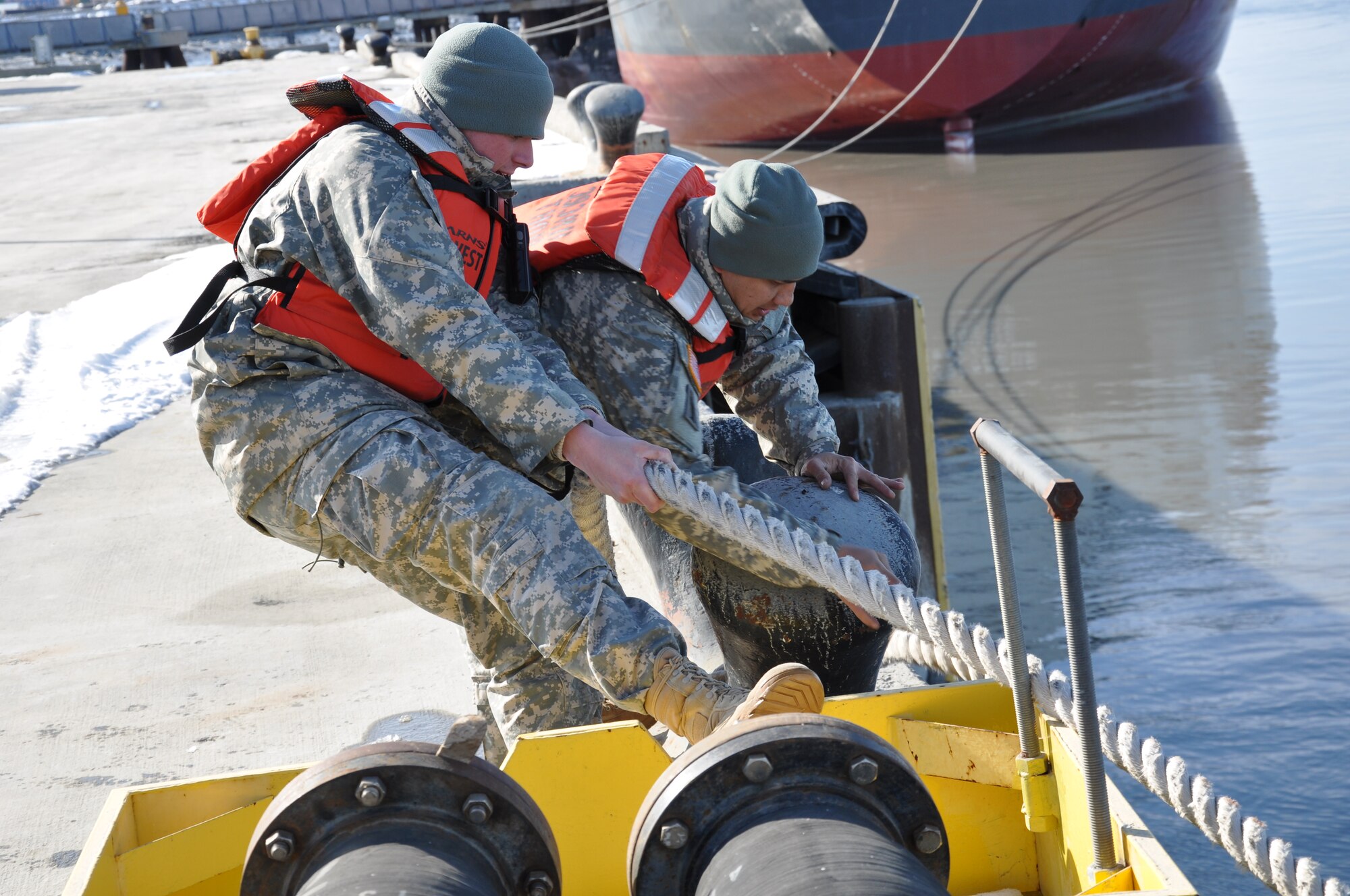 U.S. Army Spcs. Joyce Hardin and Zachary Swim, 11th Transportation Battalion, 7th Trans. Brigade (Expeditionary) watercraft operators, assist Logistics Support Vessel 7 in mooring to the pier during Joint Logistics Over-the-Shore operations as part of Alaska Shield 14 in Anchorage, Alaska, March 27, 2014. A joint task force consisting of U.S. Army, Navy, Marine Corps and Coast Guard personnel demonstrated the ability to rapidly deploy in support of the local and state authorities during the JLOTS portion of the large-scale exercise. (U.S. Army photo by Sgt. Stefanie D. Warner/Released)