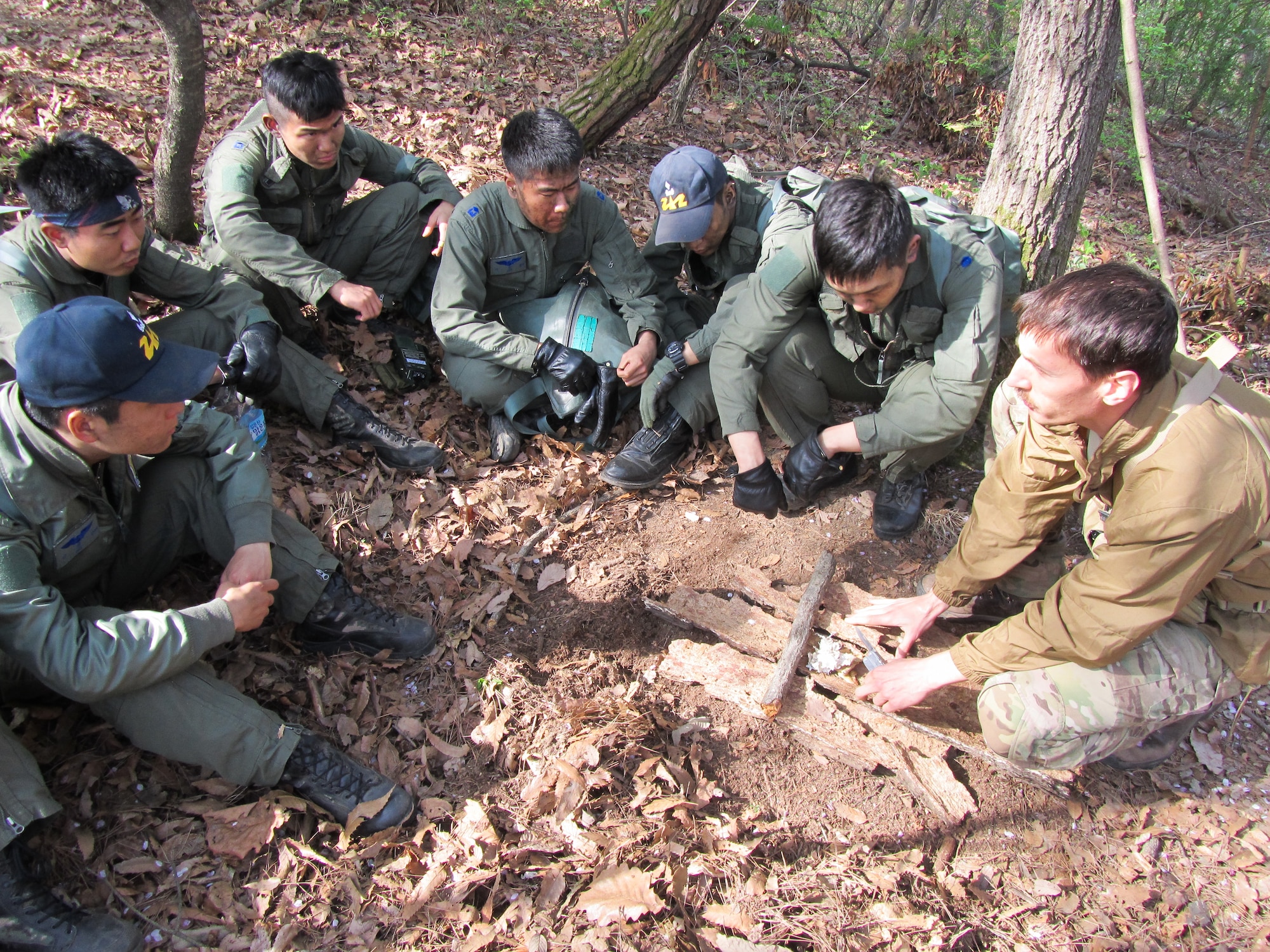 Tech. Sgt. Kurtis Douge, 8th Operations Support Squadron survival, evasion, resistance and escape specialist, explains the basics of building a fire to Republic of Korea Air Force Basic Mountain Survival Course students near Chong-Ju, ROK, April 11, 2014. The SERE specialist demonstrated survival techniques and evaluated and provided recommendations to improve the overall course taken by ROK survival students. (U.S. Air Force Courtesy Photo)