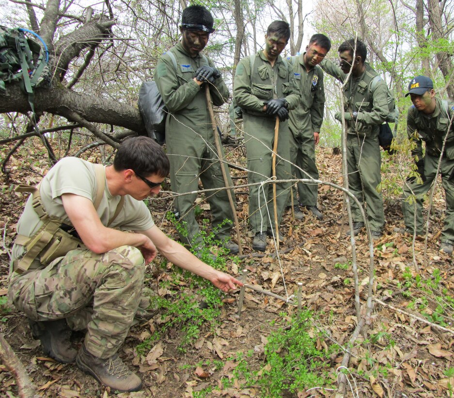 Tech. Sgt. Kurtis Douge, 8th Operations Support Squadron survival, evasion, resistance and escape specialist, shows Republic of Korea Air Force Basic Mountain Survival Course students how to build an animal snare near Chong-Ju, ROK, April 10, 2014. The SERE specialist demonstrated survival techniques and evaluated and provided recommendations to improve the overall course taken by ROK survival students. (U.S. Air Force Courtesy Photo)