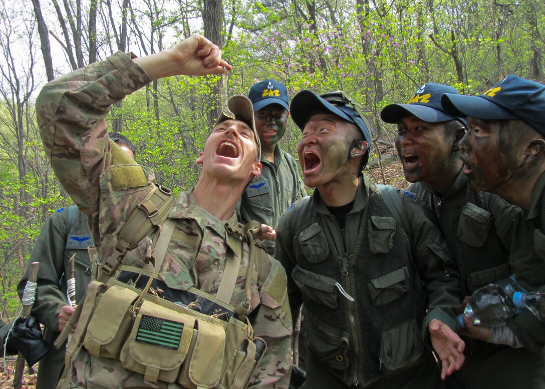 Tech. Sgt. Kurtis Douge, 8th Operations Support Squadron survival, evasion, resistance and escape specialist, teaches Republic of Korea Air Force Basic Mountain Survival Course students about overcoming food aversions prior to eating salamander eggs near Chong-Ju, ROK, April 9, 2014. The SERE specialist demonstrated survival techniques and evaluated and provided recommendations to improve the overall course taken by ROK survival students. (U.S. Air Force Courtesy Photo)