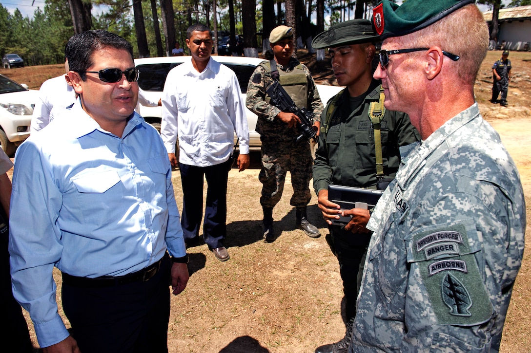 Honduran President Juan Orlando Hernandez, left, speaks with a U.S. Army Special Forces soldier in Tegucigalpa, Honduras, April 7, 2014. U.S. and Colombian soldiers gave Hernandez and U.S. Ambassador to Honduras Lisa Kubiske a tour of the training facility for Toma Integral Gubernamental de Respuesta Especial de Serguridad, the Honduran anti-trafficking police unit known as Tigres, on Soto Cano Air Base, Honduras.