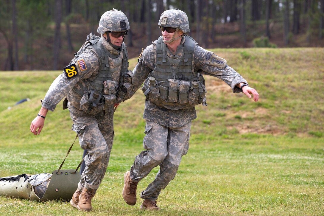 Army Capt. Steven Crowe, right, and Army Staff Sgt. Matthew Boesch pull a litter during the competition on Camp Rogers, Fort Benning, Ga., April 11, 2014. Crowe and Boesch are assigned to the 5th Special Forces Group.