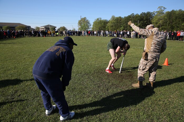 Service members with Combat Logistics Regiment 25, 2nd Marine Logistics Group encourage a Marine during the “Dizzy Izzy” at a field meet aboard Camp Lejeune, N.C., April 16, 2014. The regiment held the field meet to build camaraderie among the units within CLR-25.