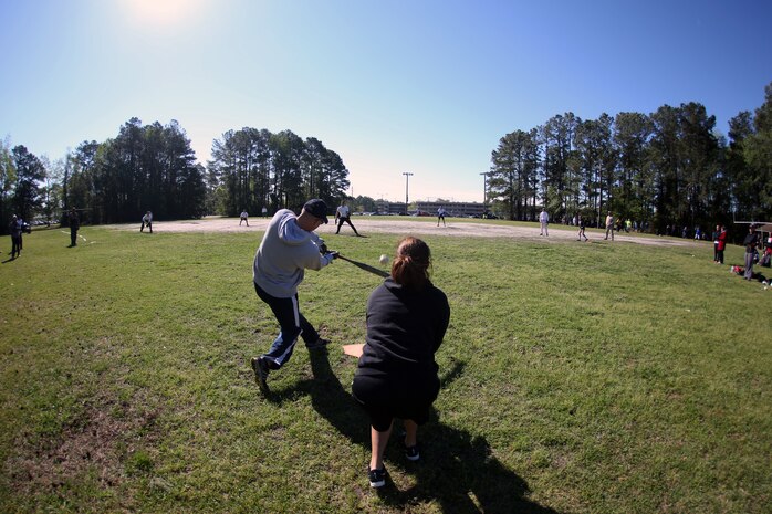 A service member with Combat Logistics Regiment 25, 2nd Marine Logistics Group swings his bat during a softball game at a field meet aboard Camp Lejeune, N.C., April 16, 2014. Teams comprised of sailors and Marines from each unit competed for the most points in a variety of events, which included softball, tug-of-war and a buddy race, and the highest total score in the regiment. 