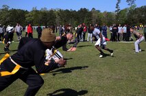 Marines and sailors with Combat Logistics Regiment 25, 2nd Marine Logistics Group face off during a flag football game at a field meet aboard Camp Lejeune, N.C., April 16, 2014. The units within CLR-25 competed against each other for bragging rights at several events, which also included basketball, a relay race and tire flip competition.