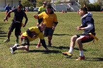 A sailor with 2nd Medical Battalion, Combat Logistics Regiment 25, 2nd Marine Logistics Group slides while trying to avoid Marines on a rival team during a flag football game at a field meet aboard Camp Lejeune, N.C., April 16, 2014. Units from Camp Lejeune and Marine Corps Air Station Cherry Point came together to build stronger bonds within the regiment.