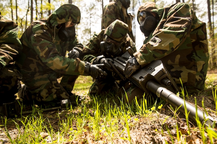 Marines with 2nd Maintenance Battalion, 2nd Marine Logistics Group assemble a Mark 19 grenade launcher while garbed in Mission Oriented Protective Posture gear during a super squad competition aboard Camp Lejeune, N.C., April 17, 2014. Squads participating in the competition battled fatigue for a chance to win the battalion trophy and bragging rights. (U.S. Marine Corps photo by Cpl. Shawn Valosin)