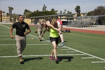 Liane R. Hager, a Harrisonville High School family and consumer sciences teacher, carries Jenny R. Bruns, a Harrisonville High School art teacher, as part of a mock Combat Fitness Test during the Educators' Workshop at Marine Corps Recruit Depot San Diego April 8, 2014. Educators from both Recruiting Station Kansas City and Lansing took part in the workshop. The workshop included the educators asking questions about the rigors of recruit training, firing the M16A4 assault rifle, amongst many other aspects of recruit training.