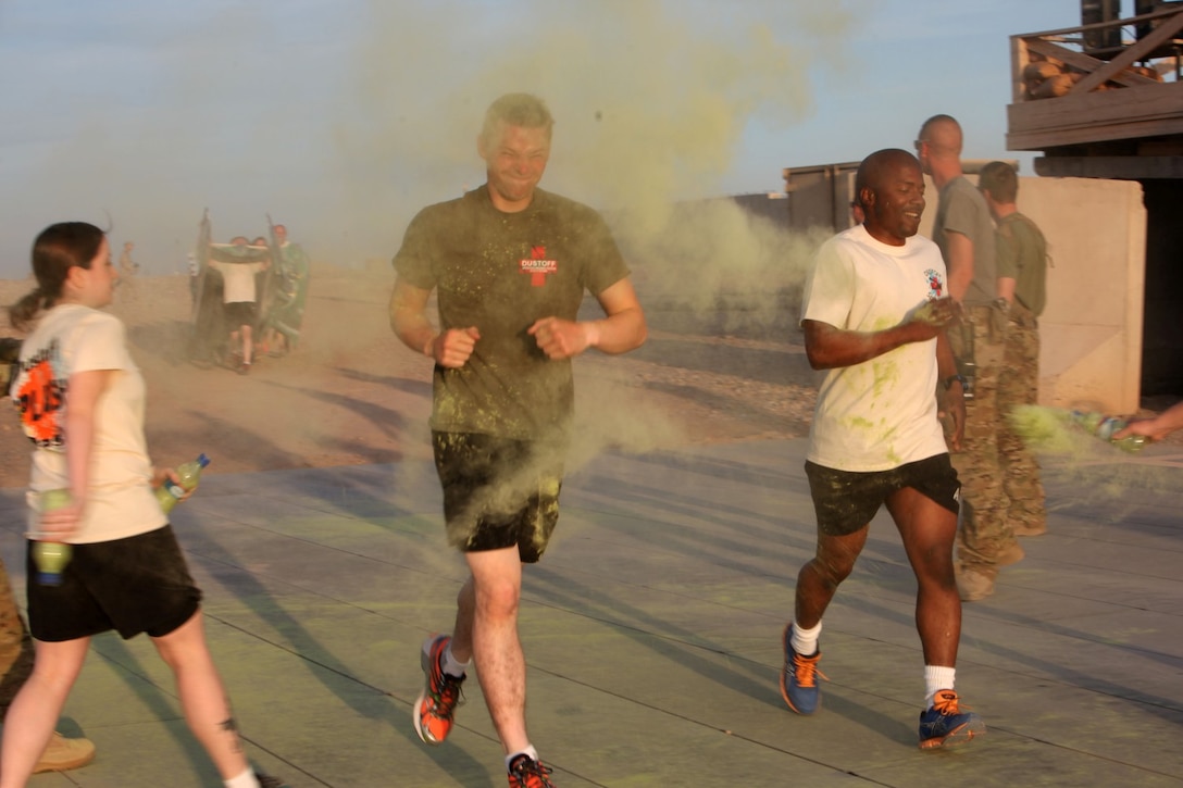 Two runners are splashed with color as they cross the 1-kilometer lap mark for the Dustoff “Splash Dash” 5k aboard Camp Bastion, Afghanistan, April 19, 2014. The medical evacuation squadron known as the “Dustoff” hosted a 5K run for service members aboard Camps Bastion and Leatherneck to bring a little fun and stress relief to the coalition forces of Regional Command (Southwest). Participants were encouraged to dress in costumes and accessories for the run and come out to build camaraderie. (USMC Photo By: Sgt. Frances Johnson/Released)