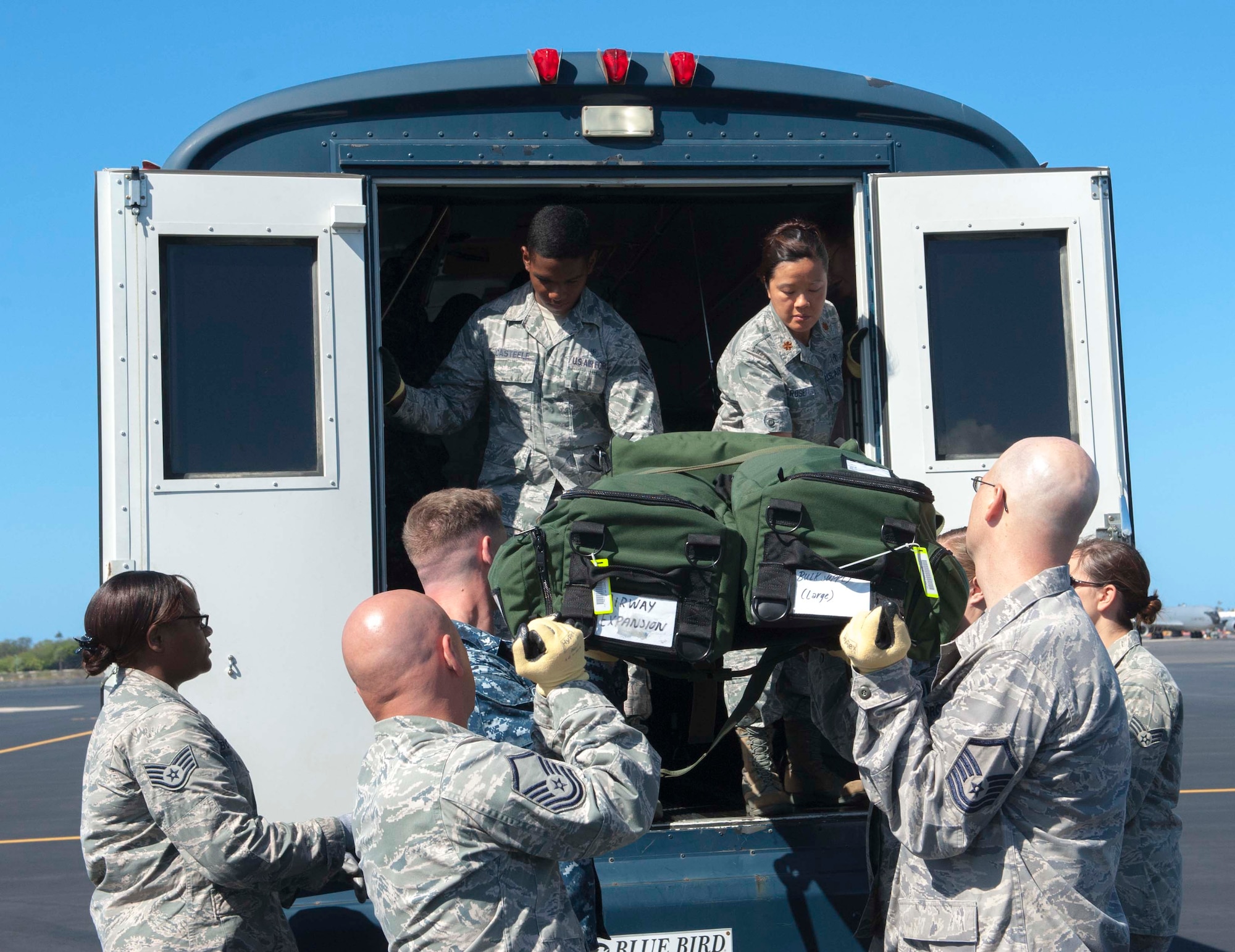 15th Medical Group Airmen and Navy medical corpsmen learn how to load a patient litter onto a personnel transport bus during a joint training session April 17, 2014 at Joint Base Pearl Harbor-Hickam, Hawaii. The training taught the medics how to properly carry a litter and proper techniques for loading and unloading patients onto a bus, C-17 Globemaster III and a HH-60 Pave Hawk helicopter. (U.S. Air Force photo/1st Lt. Andrea Dykes)