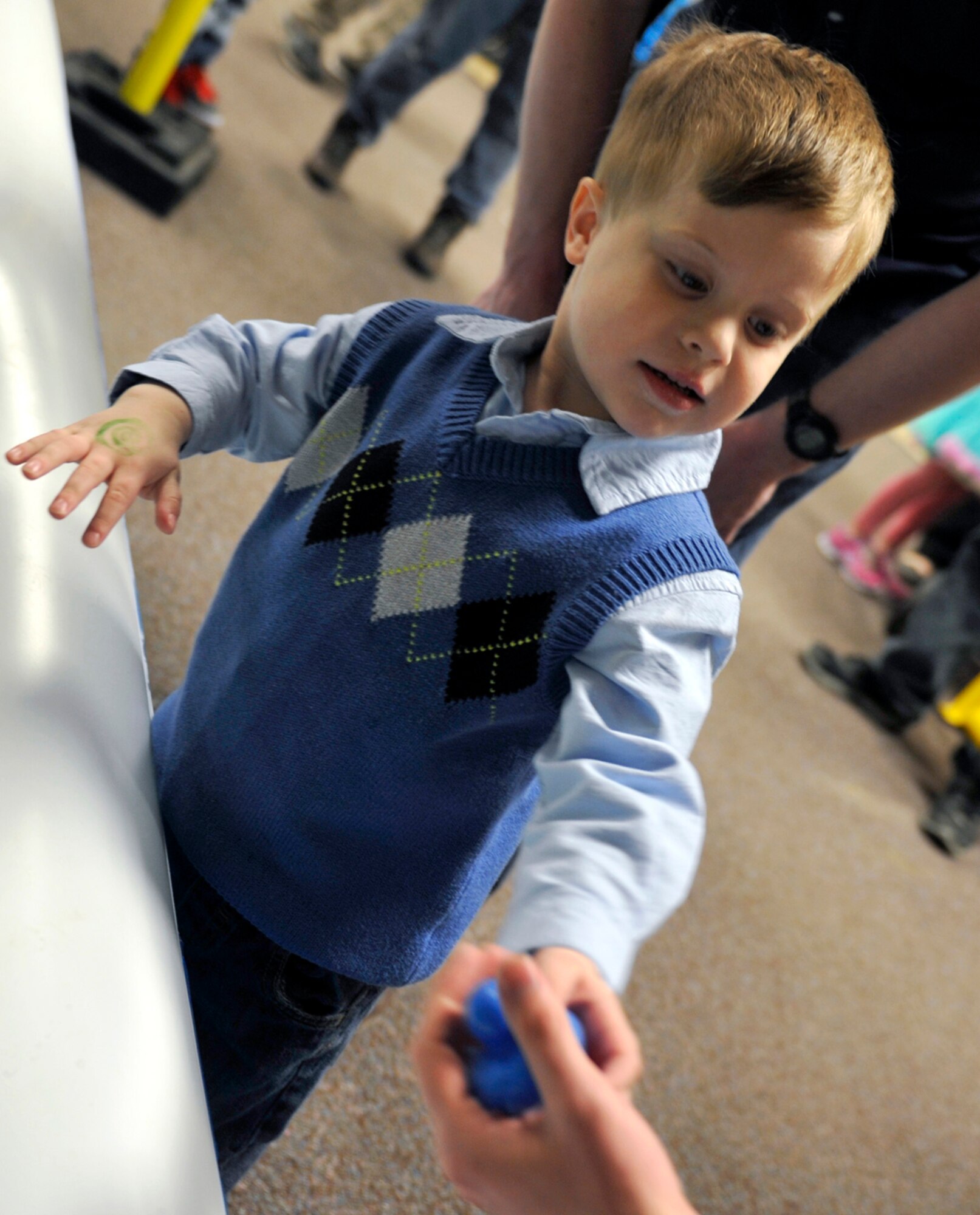 Ryan Barker, son of Air Force Capt. Gregory Barker, 962d Airborne Air Control Squadron air battle manager, hands a toy duck to a volunteer during Brunch with the Easter Bunny at the Arctic Oasis on Joint Base Elmendorf-Richardson, Alaska, April 19, 2014. An off-base store donated toys to the event as prizes for games children played during the event. (U.S. Air Force photo/Airman 1st Class Tammie Ramsouer)