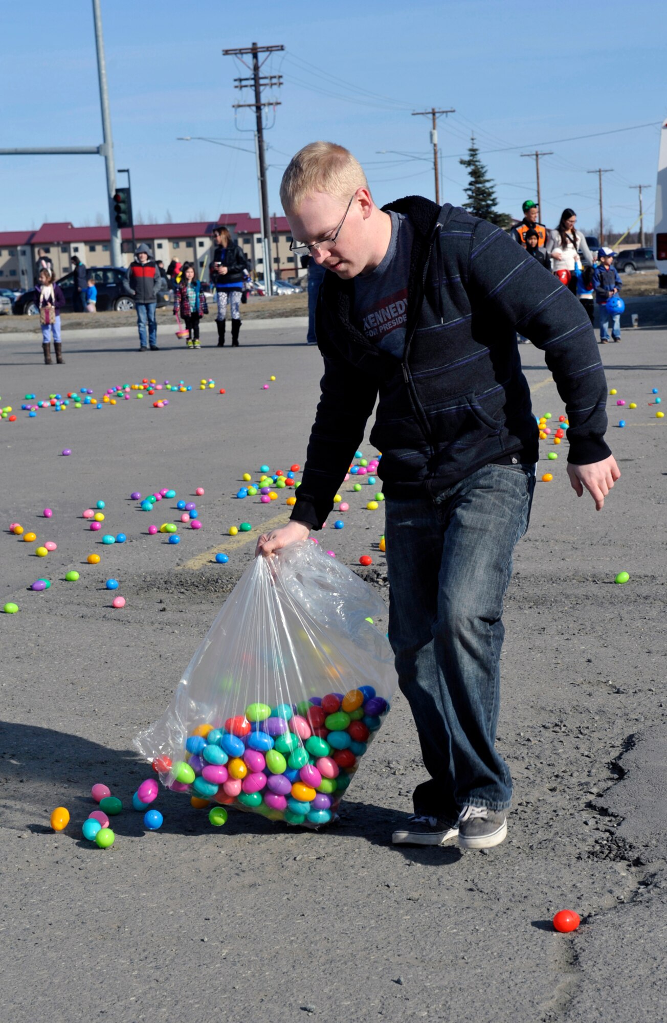 Senior Airman Trevor Cook disperses Easter eggs during the Easter Eggstravaganza at the Buckner Physical Fitness Center on Joint Base Elmendorf-Richardson, Alaska, April 19, 2014. Airman Leadership School students prepared Easter eggs for the event. Cook is an aircraft electrical and environmental specialist with the 962d Aircraft Maintenance Unit. (U.S. Air Force photo/Airman 1st Class Tammie Ramsouer)