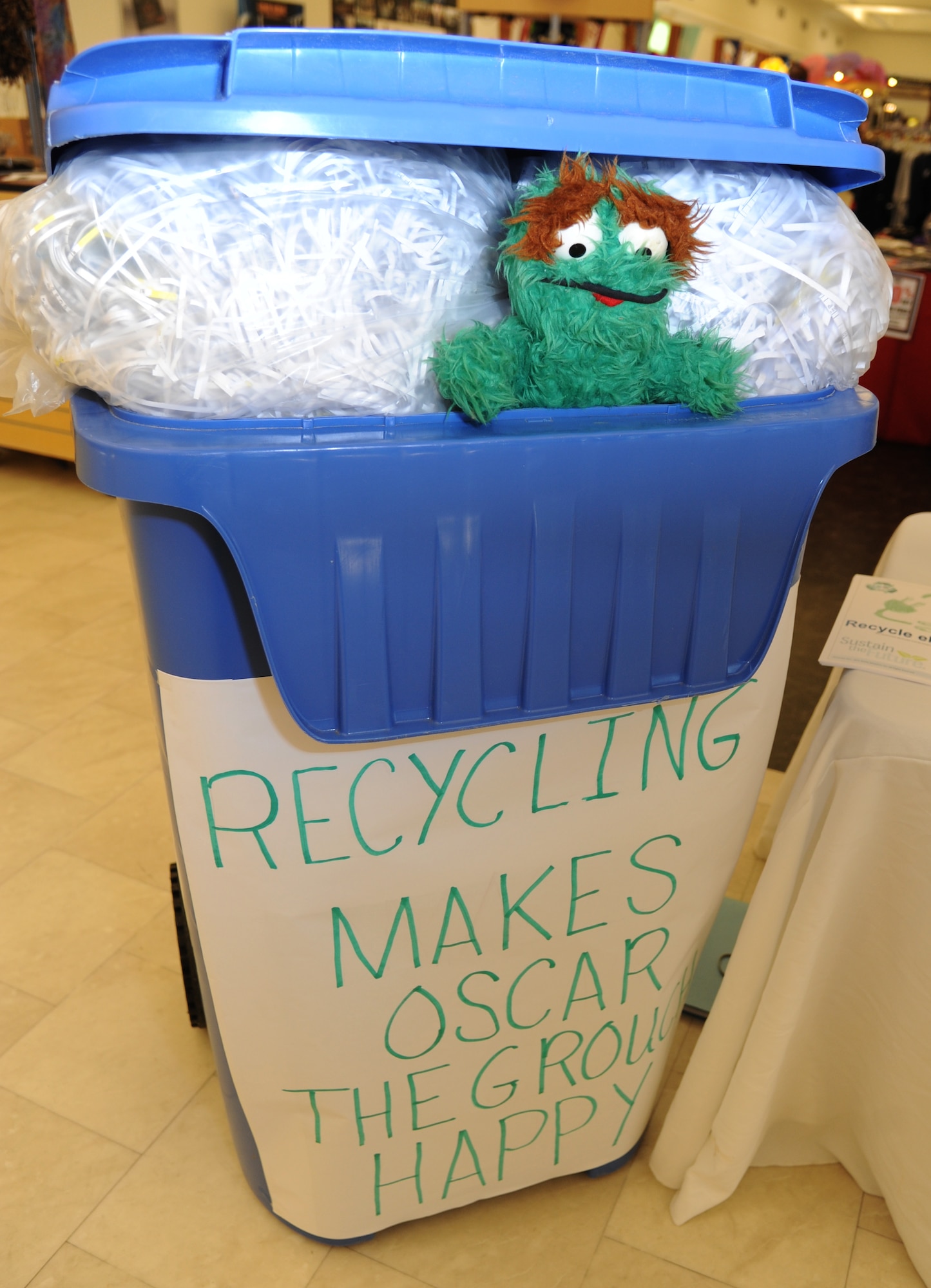 A recycling bin sits on display featuring Oscar The Grouch for Earth Day April 22, 2014, at the base exchange, Keesler Air Force Base, Miss.  Zero Waste Solutions and PAE/CEV set up booths with hand-outs and literature materials about recycling and environmental sustainability for Keesler personnel in recognition of Earth Day.  (U.S. Air Force photo by Kemberly Groue)