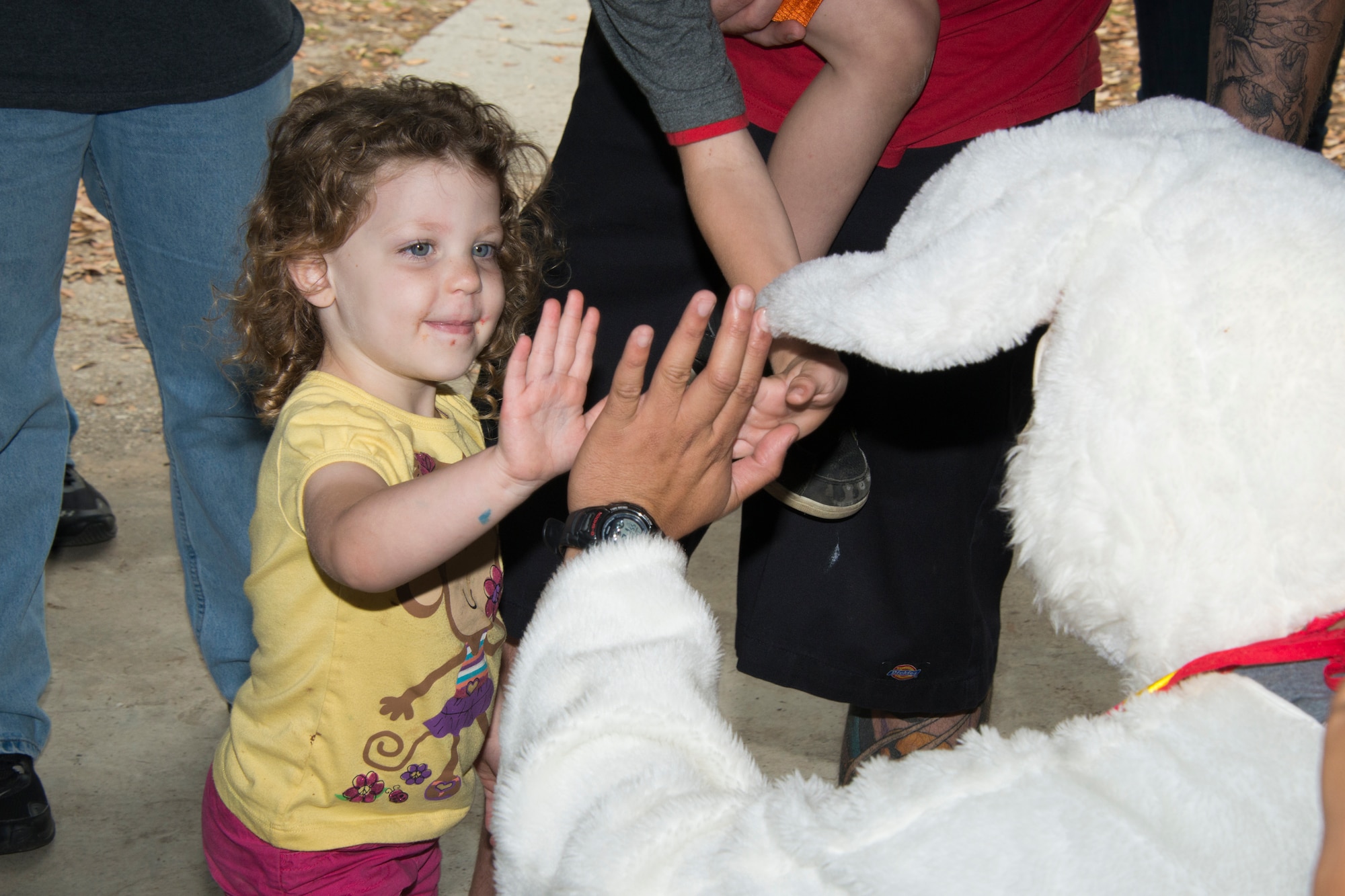 The daughter of Staff Sgts. Michael Williams, 85th Engineering Installation Squadron, and Eva Williams, 81st Dental Squadron, receives a high-five from the Easter Bunny during the squadron’s family day Easter egg hunt April 18, 2014, at the marina, Keesler Air Force Base, Miss.  The event also included a physical training session and a crawfish boil.  (U.S. Air Force photo by Adam Bond)