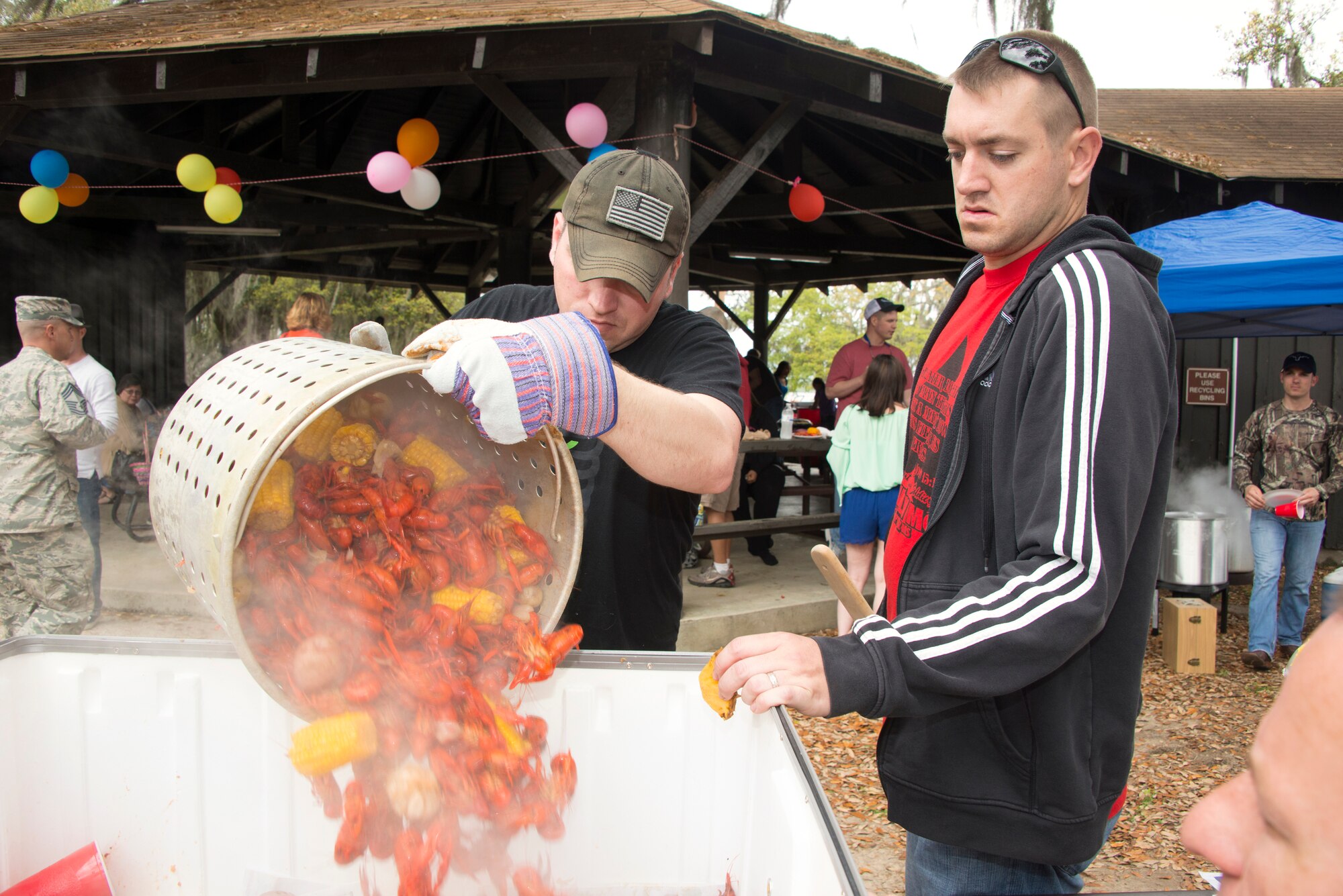 Tech. Sgt. Robert Alred, 85th Engineering Installation Squadron, dumps a freshly boiled pot of crawfish into a serving bin as Staff Sgt. Bo Brauer, 85th EIS looks on during the squadron’s family day crawfish boil April 18, 2014, at the marina, Keesler Air Force Base, Miss.  The event also included a physical training session, an Easter egg hunt and a visit by the Easter Bunny.  (U.S. Air Force photo by Adam Bond)