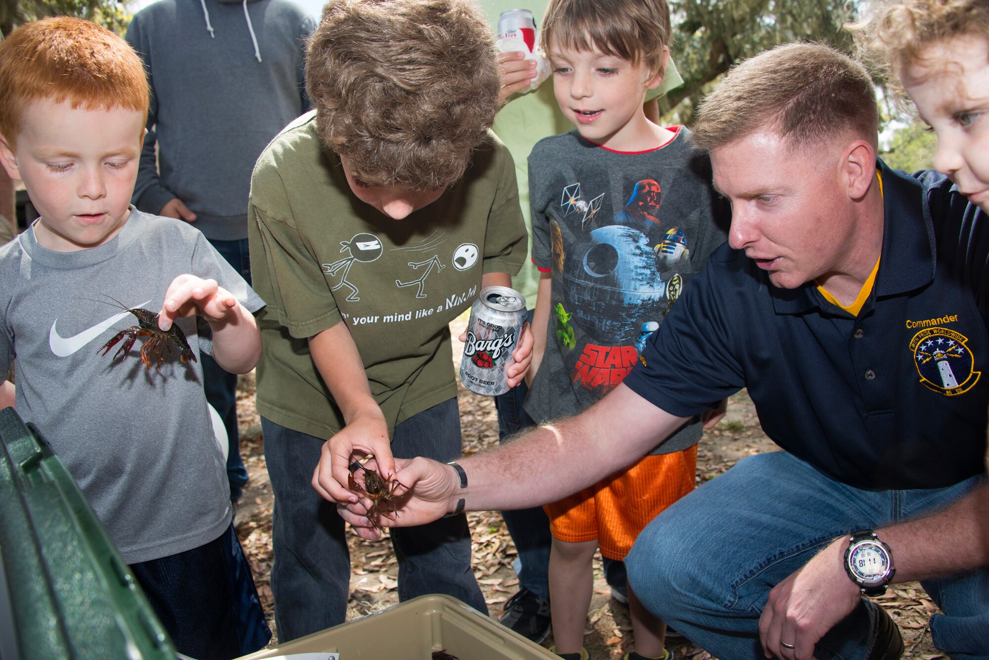 Lt. Col. James Coughlin, 85th Engineering Installation Squadron commander, demonstrates how to safely hold a crawfish to his son and his friends during the squadron’s family day crawfish boil April 18, 2014, at the marina, Keesler Air Force Base, Miss.  The event also included a physical training session, an Easter egg hunt and a visit by the Easter Bunny.  (U.S. Air Force photo by Adam Bond)