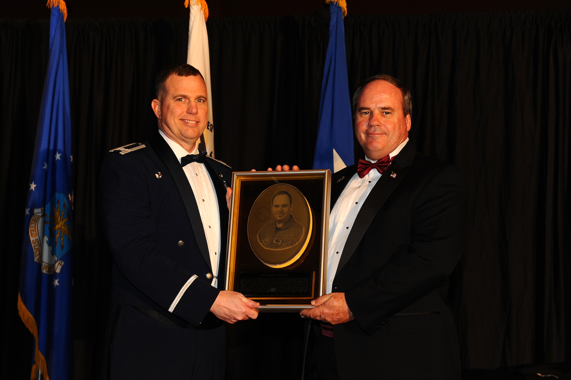 U.S. Air Force Col. Gregory M. Guillot, the 55th Wing commander, presents a Wing Hall of Fame plaque to the 2014 honoree retired U.S. Air Force Lt. Col. Ricky McMahon at the annual Birthday Ball celebration hosted by the Embassy Suites Hotel in LaVista Neb, April 12. McMahon has had a lasting impact on the 55th Wing both in his active duty and civilian careers, most notably for bringing to fruition the 338th Combat Training Squadron from an idea to a reality.  (U.S. Air Force photo by Josh Plueger/Released)