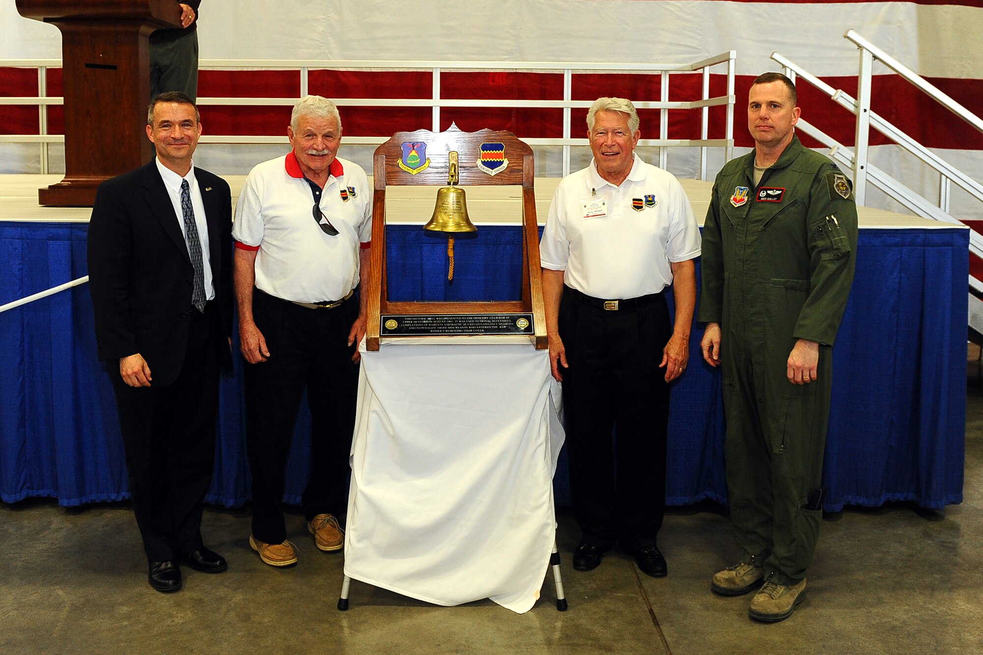 From left to right: Former 55th Wing commanders U.S. Air Force Brig. Gen. Donald Bacon, retired U.S. Air Force Brig. Gen. Regis F.A. Urschler and U.S. Air Force Col. Lawrence Mitchell, along with U.S. Air Force Col. Gregory Guillot, current 55th Wing commander, stand for a group photo with the ceremonial bell to begin the annual Tales of the 55th Ceremony held in Dock 1 of the Bennie Davis Maintenance Facility April 11. Current and formers members of Team Offutt gathered at the Tales of the 55th to share in the Wing’s rich heritage. Displays showcasing the variety of missions and squadrons encircle the audience as they shared war stories both new and old.  (U.S. Air Force photo by Josh Plueger/Released)