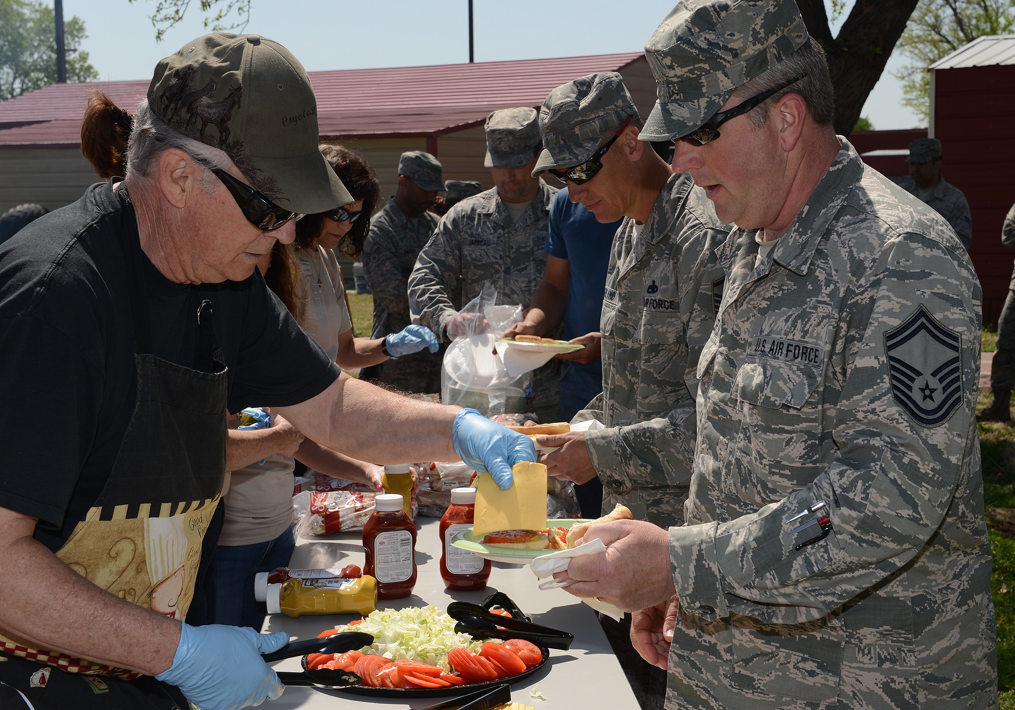 Master Sergeant Don Herbert (Ret.) serves Senior Master Sergeant Eric Erler during an Earth Day celebration at the 138th Fighter Wing, 22 April 2014.  The 138th FW Environmental Management office organized a cookout and other green activities to celebrate the day at the Tulsa Air National Guard base, Tulsa Okla.  (U.S. National Guard photo by Senior Master Sgt.  Preston L. Chasteen/Released)