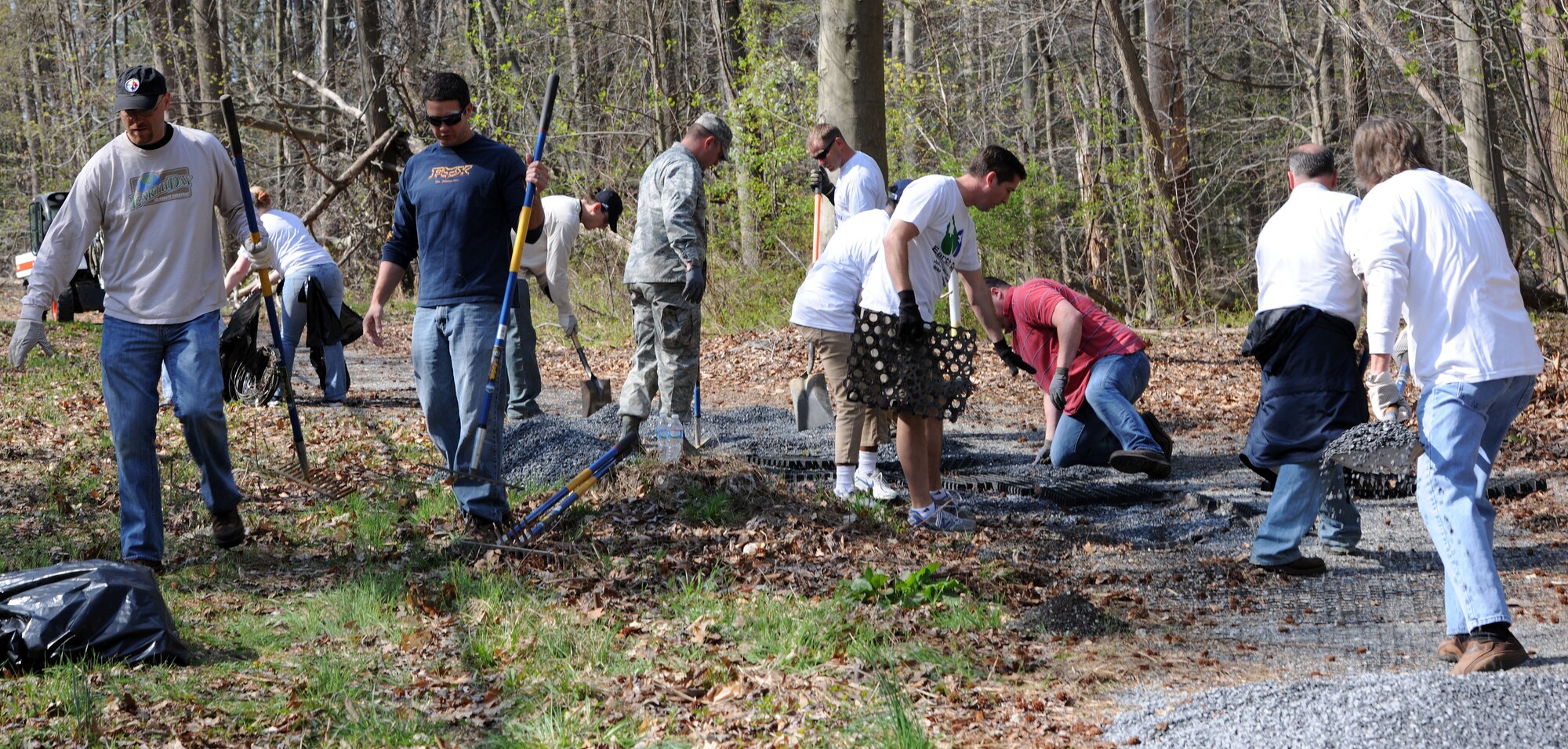 Team Andrews volunteers pick up trash and spread gravel on a trail here to recognize the 44th Annual Earth Day, April 22, 2014. The trail is primarily used by team members for walking and running. (U.S. Air Force photo/Airman 1st Class Ryan J. Sonnier)
