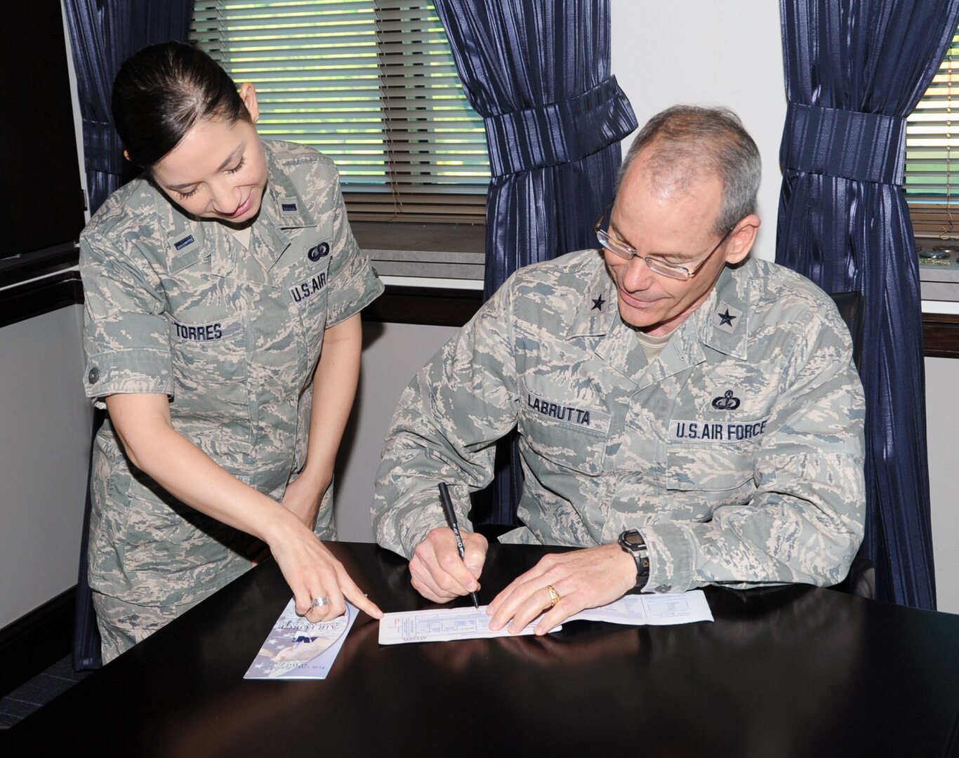 1st Lt. Amy Torres, Joint Base San Antonio Installation Project Officer for the Air Force Assistance Fund, hand delivers the 2014 AFAF donation form April 9 to Brig. Gen. Bob LaBrutta, 502nd Air Base Wing and JBSA commander. The annual Air Force Assistance Fund campaign for JBSA, which has the theme of “Commitment to Caring,” runs through May 2 and raises funds for the charitable affiliates that provide support to the Air Force family (active duty, retirees, reservists, guard and their dependents, including surviving spouses) in need. The four charities are the Air Force Aid Society, Gen. and Mrs. Curtis E. LeMay Foundation, the Air Force Village and the Air Force Enlisted Village. These organizations help Air Force people with aid in an emergency, with educational needs, or to have a secure retirement home for widows or widowers of Air Force members in need of financial assistance. These charities are not a part of the Combined Federal Campaign lineup. The combined goal for JBSA this year is $363,000. Visit http://www.afassistancefund.org for information. (U.S. Air Force photo by Olivia Mendoza)