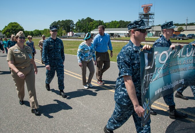 (Left to right) Marcia Ziemba, Space and Naval Warfare Systems Center Atlantic executive officer, Lt. j.g. Pete McLaughlin, Naval Support Activity administration officer, Capt. Amy Burin, SSC Atlantic commanding officer, and Steve Dunn, SSC Atlantic executive director, are led by NSA's Petty Officer 1st Class  Seth Oswald and SSC Atlantic's Petty Officer 2nd Class David Gates on their mile-long walk during the Sexual Assault Awareness Month event "Walk a Mile in their Shoes," April 22, 2014, on Joint Base Charleston - Weapons Station. (U.S. Navy photo/Joe Bullinger)