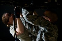 Airman 1st Class Dustin Lumpkin assists SrA Kasey Castor, 5th Aircraft Maintenance Squadron weapons load crew members, with bomb rack preparation on a B-52H Stratofortress during a weapons-loading competition at Minot Air Force Base, N.D., April 17, 2014. Each load crew consists of four Airmen who are evaluated every month on how well they load various types of weapons. (U.S. Air Force photo/Senior Airman Brittany Y. Auld)