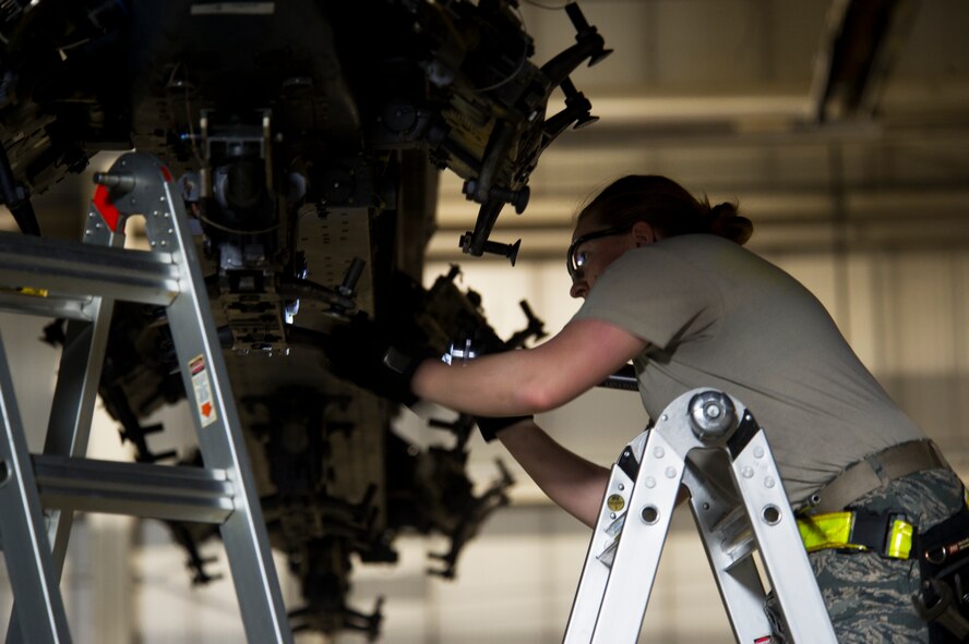 Senior Airman Kasey Castor, 5th Aircraft Maintenance Squadron weapons load crew member, performs a bomb rack preparation on a B-52H Stratofortress during a weapons-loading competition at Minot Air Force Base, N.D., April 17, 2014. As part of Air Force Global Strike Command, load crews work endlessly to preserve our nation’s security by providing combat-ready forces for nuclear deterrence and global strike operations. (U.S. Air Force photo/Senior Airman Brittany Y. Auld)