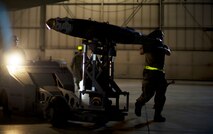 Airman 1st Class Dustin Lumpkin and Senior Airman Kasey Castor, 5th Aircraft Maintenance Squadron weapons load crew members, use a MJ-1 Jammer to load a Joint Direct Attack Missile trainer on a B-52H Stratofortress during a weapons-loading competition at Minot Air Force Base, N.D., April 17, 2014. Each load crew consists of four Airmen who are evaluated every month on how well they load various types of weapons. (U.S. Air Force photo/Senior Airman Brittany Y. Auld)