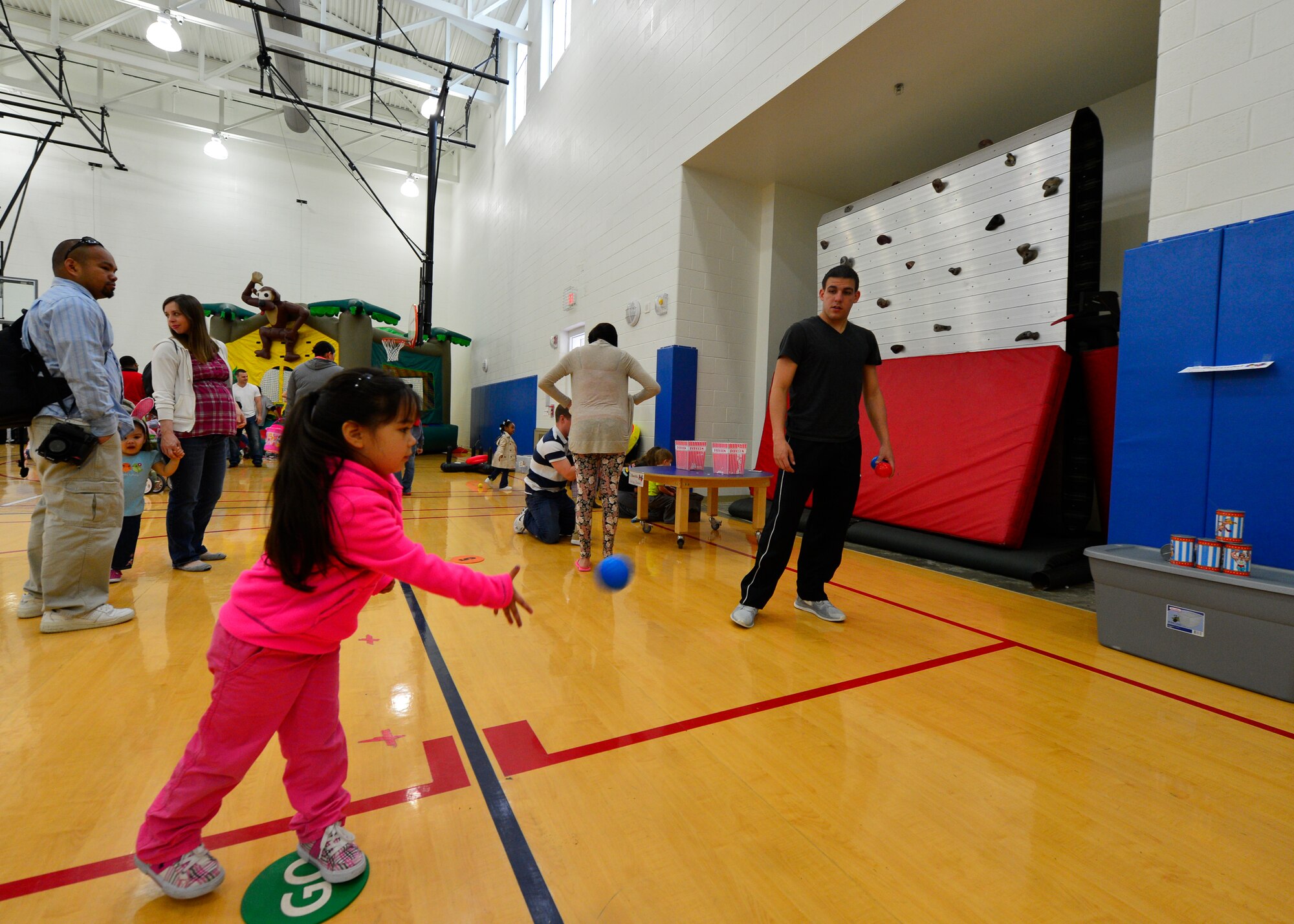 Alana Pacer, daughter of John Crowe, 817th Global Mobility Squadron loadmaster, throws a ball at a stack of cans during an Easter carnival event April, 19, 2014, at the Youth Center on Dover Air Force Base, Del. The Easter carnival had a variety of games and prizes for children to win and included a bounce house. (U.S. Air Force photo/ Airman 1st Class William Johnson)