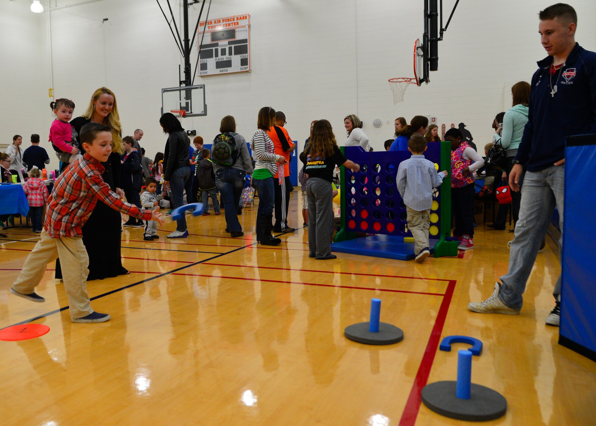 Jennifer Thomas, wife of Staff Sgt. Corydon Thomas, 436th Aerial Port Squadron passenger service supervisor, watches her son, Andrew Kach, throw horse shoes during an Easter carnival April, 19, 2014, at the Youth Center on Dover Air Force Base, Del. A variety of games and activities were set up in the gymnasium for military families to play. (U.S. Air Force photo/Airman 1st Class William Johnson)