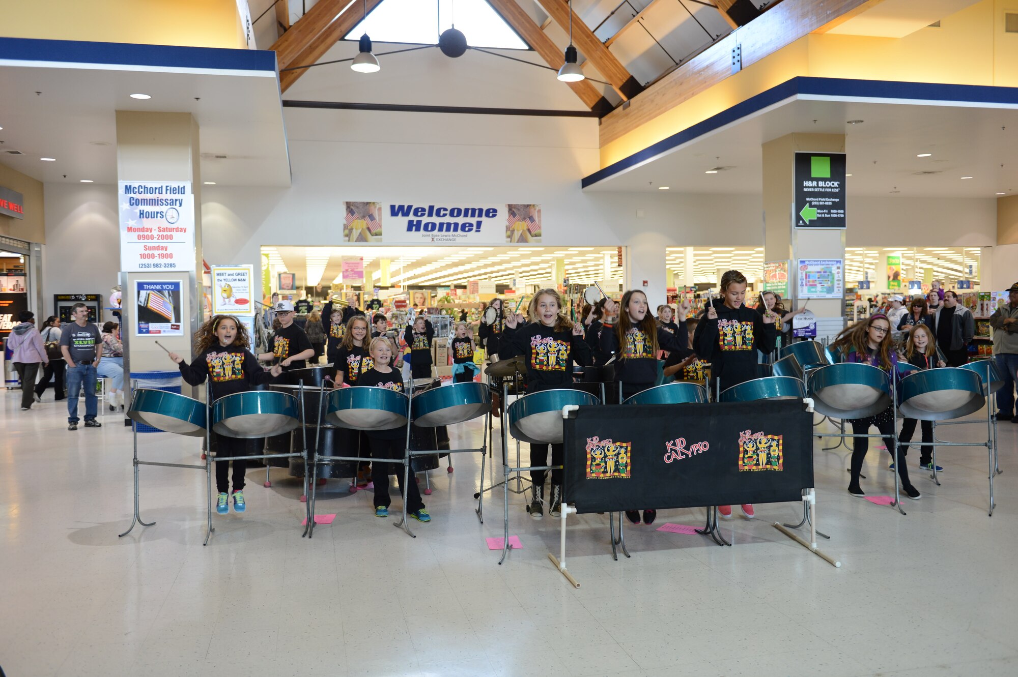 Kid Calypso, a steel drum band, from Tapteal Elementary School, West Richland, Wash., perform for Team McChord Airmen and their families at the McCord Main Exchange, April 18, 2014, at Joint Base Lewis-McChord, Wash. More than 50 children and their parents and chaperones made the four hour drive to visit McChord and perform for servicemembers. (U.S. Air Force photo/A1C Jacob Jimenez)