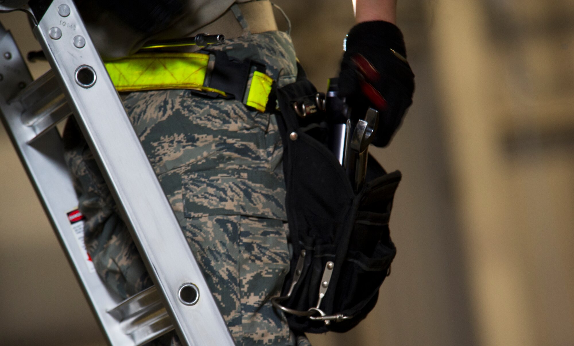 Senior Airman Kasey Castor, 5th Aircraft Maintenance Squadron weapons load crew member  grabs a tool from her belt while loading a Joint Direct Attack Missile trainer on a B-52H Stratofortress during a weapons-loading competition at Minot Air Force Base, N.D., April 17, 2014. As part of Air Force Global Strike Command, load crews work endlessly to preserve our nation’s security by providing combat-ready forces for nuclear deterrence and global strike operations. (U.S. Air Force photo/Senior Airman Brittany Y. Auld)

