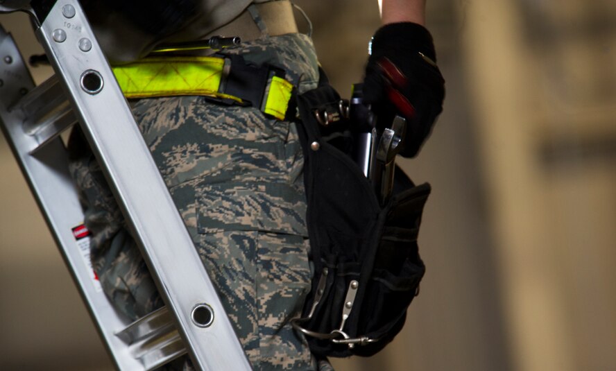 Senior Airman Kasey Castor, 5th Aircraft Maintenance Squadron weapons load crew member  grabs a tool from her belt while loading a Joint Direct Attack Missile trainer on a B-52H Stratofortress during a weapons-loading competition at Minot Air Force Base, N.D., April 17, 2014. As part of Air Force Global Strike Command, load crews work endlessly to preserve our nation’s security by providing combat-ready forces for nuclear deterrence and global strike operations. (U.S. Air Force photo/Senior Airman Brittany Y. Auld)

