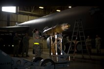 Senior Airman Kasey Castor, 5th Aircraft Maintenance Squadron weapons load crew member, prepares to load a Joint Direct Attack Missile trainer on a B-52H Stratofortress during a weapons-loading competition at Minot Air Force Base, N.D., April 17, 2014. As part of Air Force Global Strike Command, load crews work endlessly to preserve our nation’s security by providing combat-ready forces for nuclear deterrence and global strike operations. (U.S. Air Force photo/Senior Airman Brittany Y. Auld)