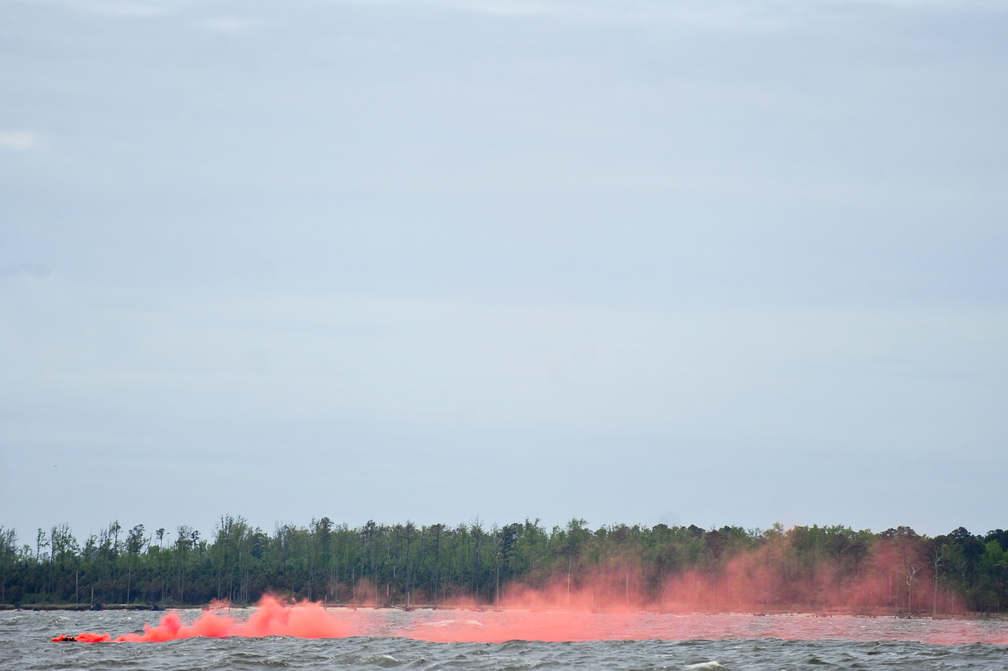 A downed pilot releases smoke to mark his location during a search and rescue training mission, April 18, 2014, in the Neuse River outside Oriental, N.C.  During the training mission, two 336th Fighter Squadron aircrew members were required to survive, evade and coordinate rescue.  The operation was part of exercise RAZOR TALON, a 4th Fighter Wing training initiative that provides a low-cost, large-force exercise training opportunity for joint East Coast tactical and support aviation units. (U.S. Air Force photo/Airman 1st Class Brittain Crolley)  