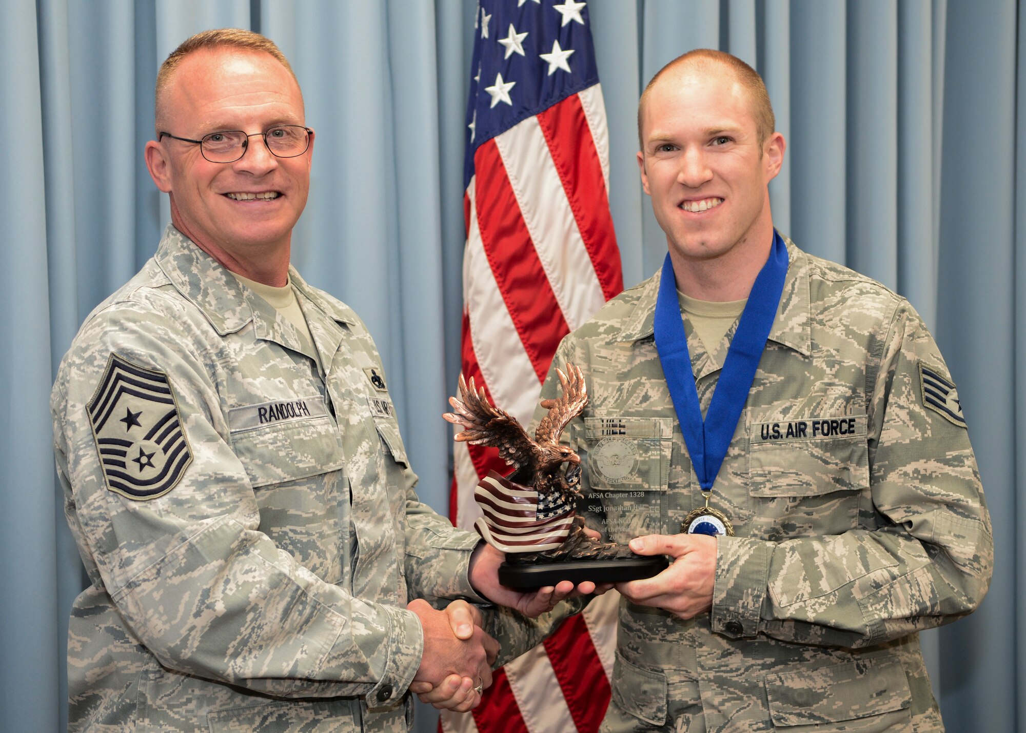 Chief Master Sgt. Brian Randolph (left), 412th Test Wing command chief, presents Staff Sgt. Jonathan Hill, 412th Communications Squadron, with the Non-Commissioned Officer of the Year award. (U.S. Air Force photo by Jet Fabara)
