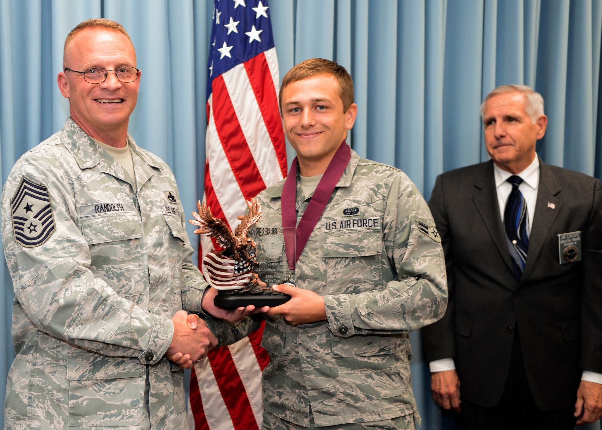 Command Chief Master Sergeant Brian Randolph (left), 412th Test Wing and retired Chief Master Sgt. (Retired) James Lokovic (right), Air Force Sergeants Association Division 6 Legislative Affairs Trustee, present Airmen 1st Class Andrew Pietszak, 412th Communications Squadron, with the Air Force Sergeants Association Airmen of the Year award. (U.S. Air Force photo by Jet Fabara)