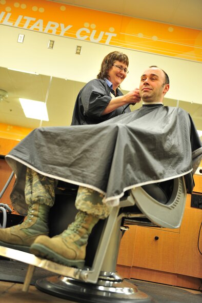 Melissa Todd, a barbershop concessionaire, cuts an Airman’s hair at Minot Air Force Base, N.D., April 20, 2014. The barbershop provides haircuts to Airmen and their families who work and live on base, approximately 7,000 people. They also provide cuts to members of any age, young and old. (U.S. Air Force photo/Senior Airman Malia Jenkins)