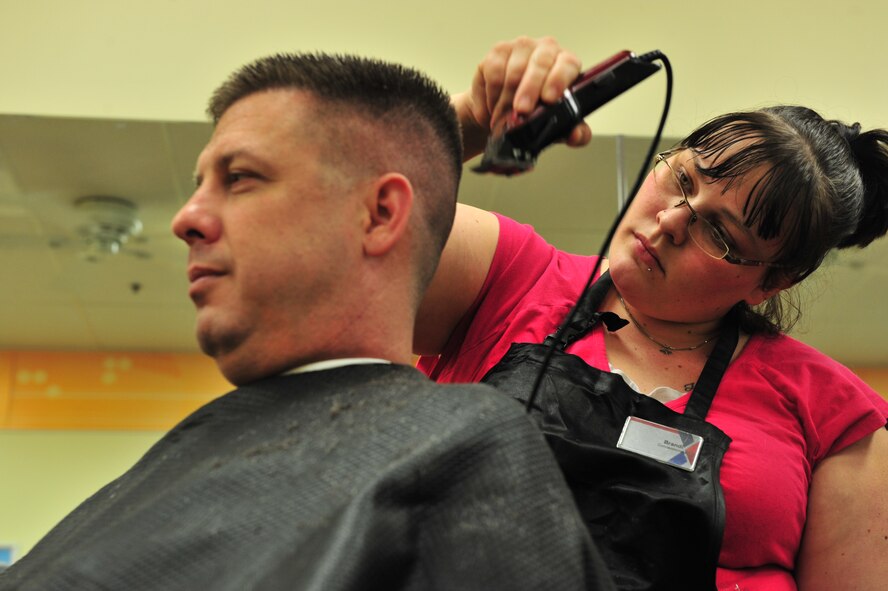 Brandi Brewer, a barbershop concessionaire, cuts a customer’s hair at Minot Air Force Base, N.D., April 20, 2014. The barbershop provides haircuts to Airmen and their families who work and live on base, approximately 7,000 people. They also provide cuts to members of all ages. (U.S. Air Force photo/Senior Airman Malia Jenkins)   
