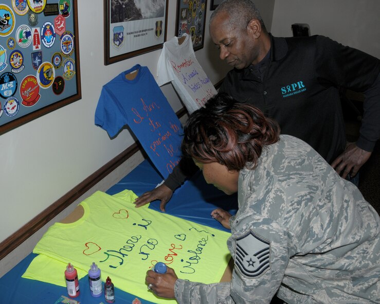 MSgt. Francenia Reed-McKnight, administrative specialist, 914th Aeromedical Evacuation Squadron uses her creative talent to create a message on a t-shirt to show her support to End Sexual Assault & Domestic Violence while Allan Davidson, weapons safety manager, 914th Airlift Wing looks on at the Niagara Falls Air Reserve Station, NY on April, 18, 2014. Reed-McKnight was one of many base employees who took part in several activities promoting Sexual Assault Awareness Month. (U.S. Air Force photo by Peter Borys)