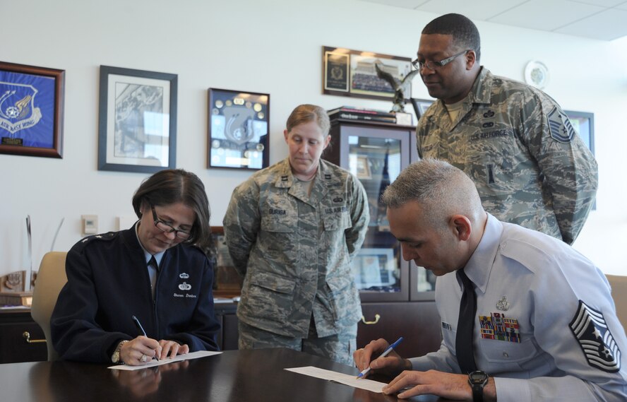 Air Force District of Washington Commander Maj. Gen. Sharon K. G. Dunbar and AFDW Command Chief Master Sgt. Jose LugoSantiago fill out their Air Force Assistance Fund donations forms as Capt. Denise Duriga and Master Sgt. Jeremy Peagler look on at Joint Base Andrews, Md., April 21, 2014. Duriga, AFDW Manpower and Personnel Directorate, and Peagler, 779th Medical Operations Squadron first sergeant, are this year’s AFDW AFAF project officers. The AFAF campaign, which is themed “Commitment to Caring,” runs through May 9, 2014. (U.S. Air Force photo/Master Sgt. Tammie Moore)