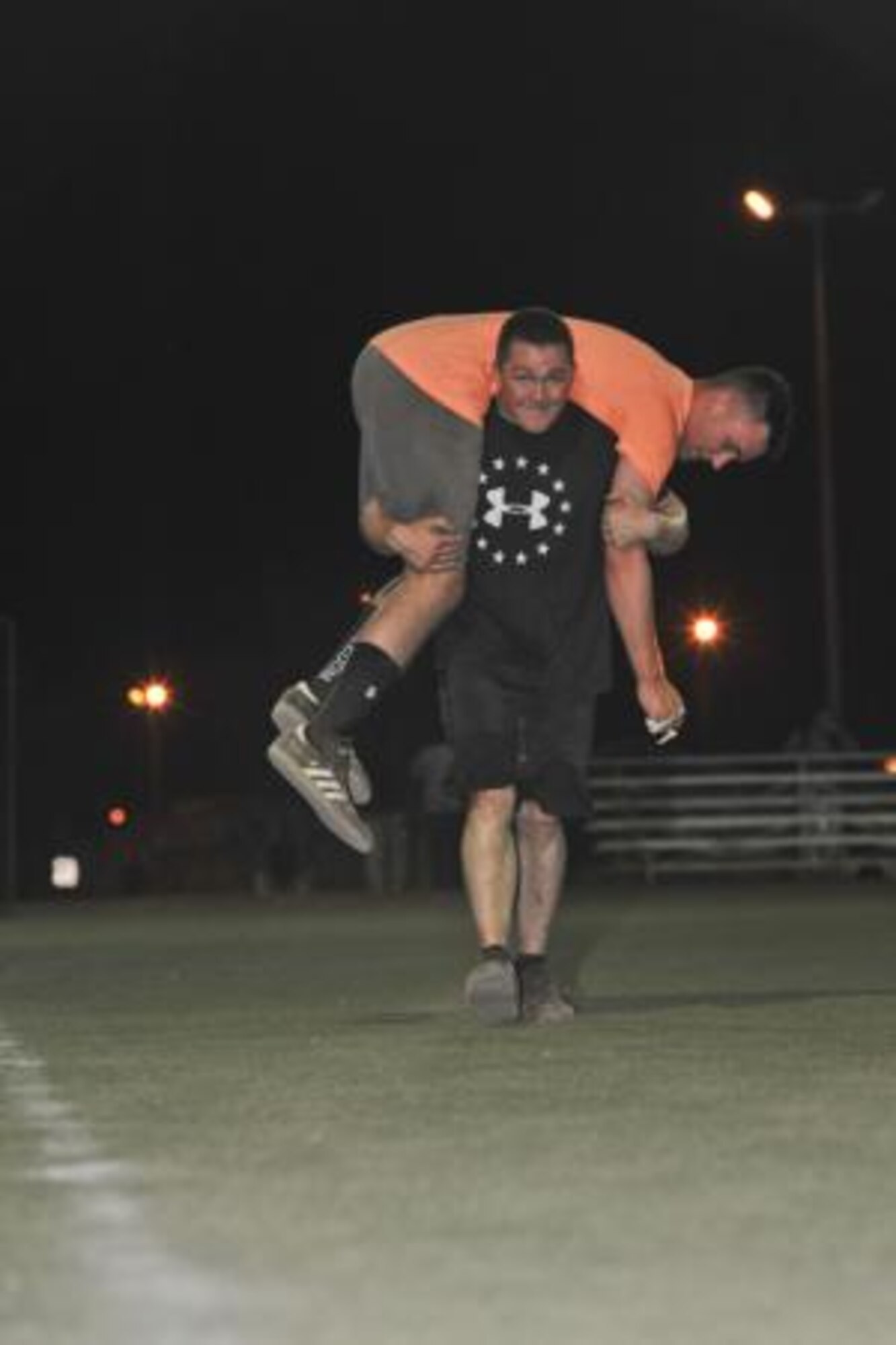 Curtis Cain carries Jordan Schall during the buddy carry portion of the Memorial Mash in honor of U.S. Air Force Chief Master Sgt. Nick McCaskill on Camp Lemonnier, Djibouti, April 6, 2014. Members of the 82nd Expeditionary Rescue Squadron organized the mash in remembrance of the one year anniversary of McCaskill’s death in Afghanistan. More than 70 people, split into 18 teams, competed in the event, which consisted of a total of 1,010 repetitions between 11 exercises. The repetitions symbolized McCaskill’s operating initials, a unique “XX.” Cain, a U.S. Air Force staff sergeant, and Schall, an airman first class, are both members of the 449th Air Expeditionary Group security forces detachment 1. (U.S. Air Force photo by Staff Sgt. Christopher Gross)
