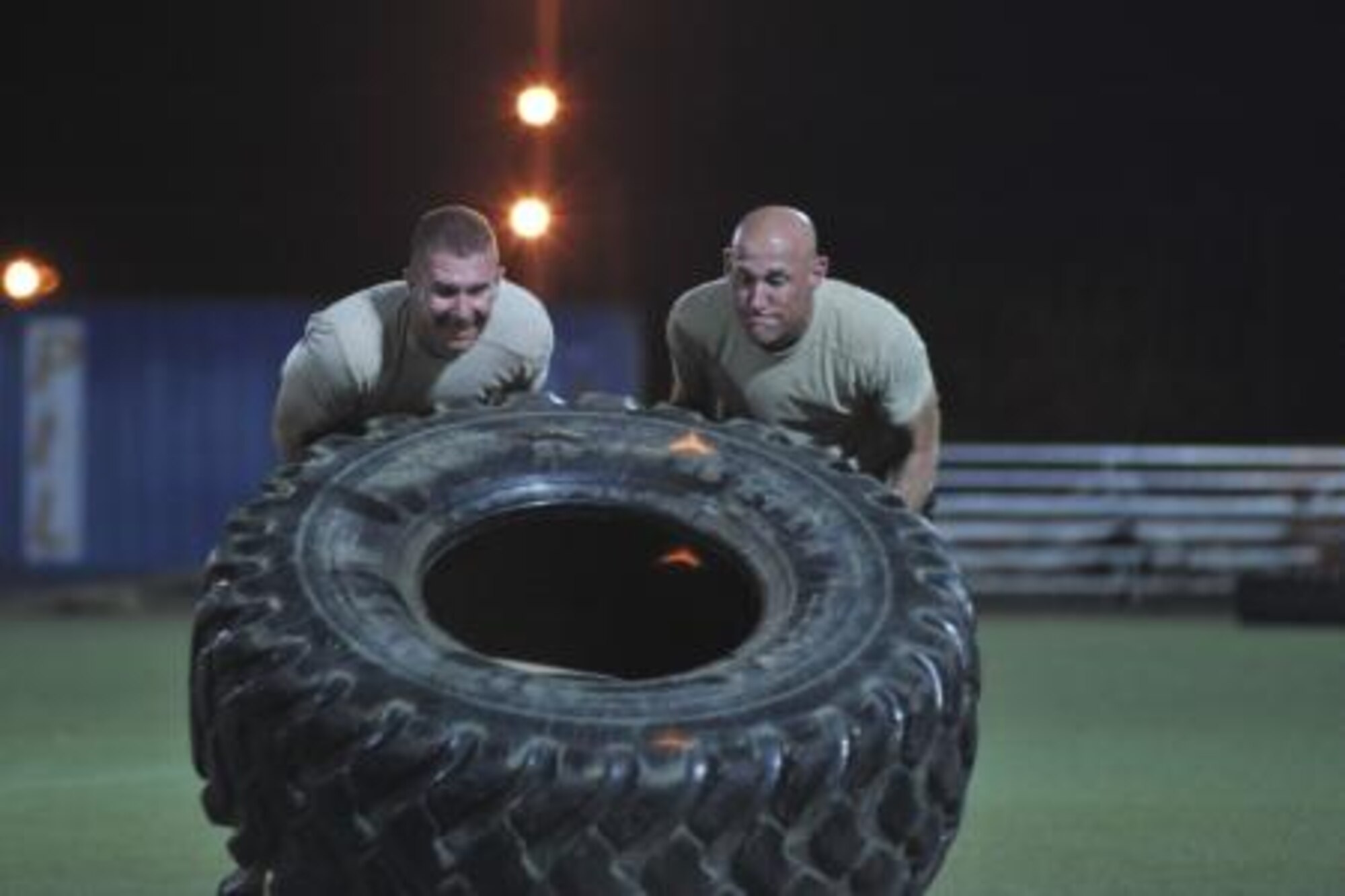 Service members flip a tire during the Memorial Mash in honor of U.S. Air Force Chief Master Sgt. Nick McCaskill on Camp Lemonnier, Djibouti, April 6, 2014. Members of the 82nd Expeditionary Rescue Squadron organized the mash in remembrance of the one year anniversary of McCaskill’s death in Afghanistan. More than 70 people, split into 18 teams, competed in the event, which consisted of a total of 1,010 repetitions between 11 exercises. The repetitions symbolized McCaskill’s operating initials, a unique “XX.” (U.S. Air Force photo by Staff Sgt. Christopher Gross)

